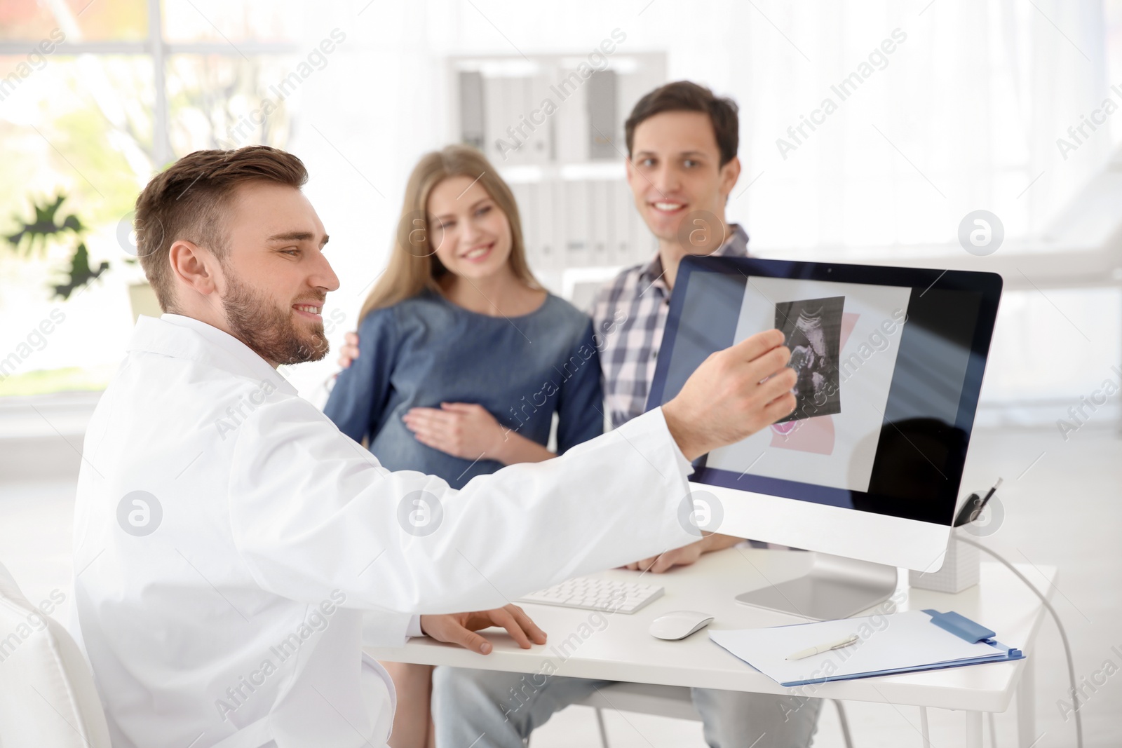 Photo of Gynecology consultation. Future parents with doctor in hospital