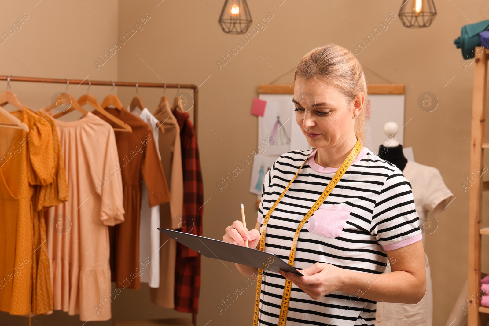 Photo of Dressmaker drawing sketch of garment in workshop, space for text