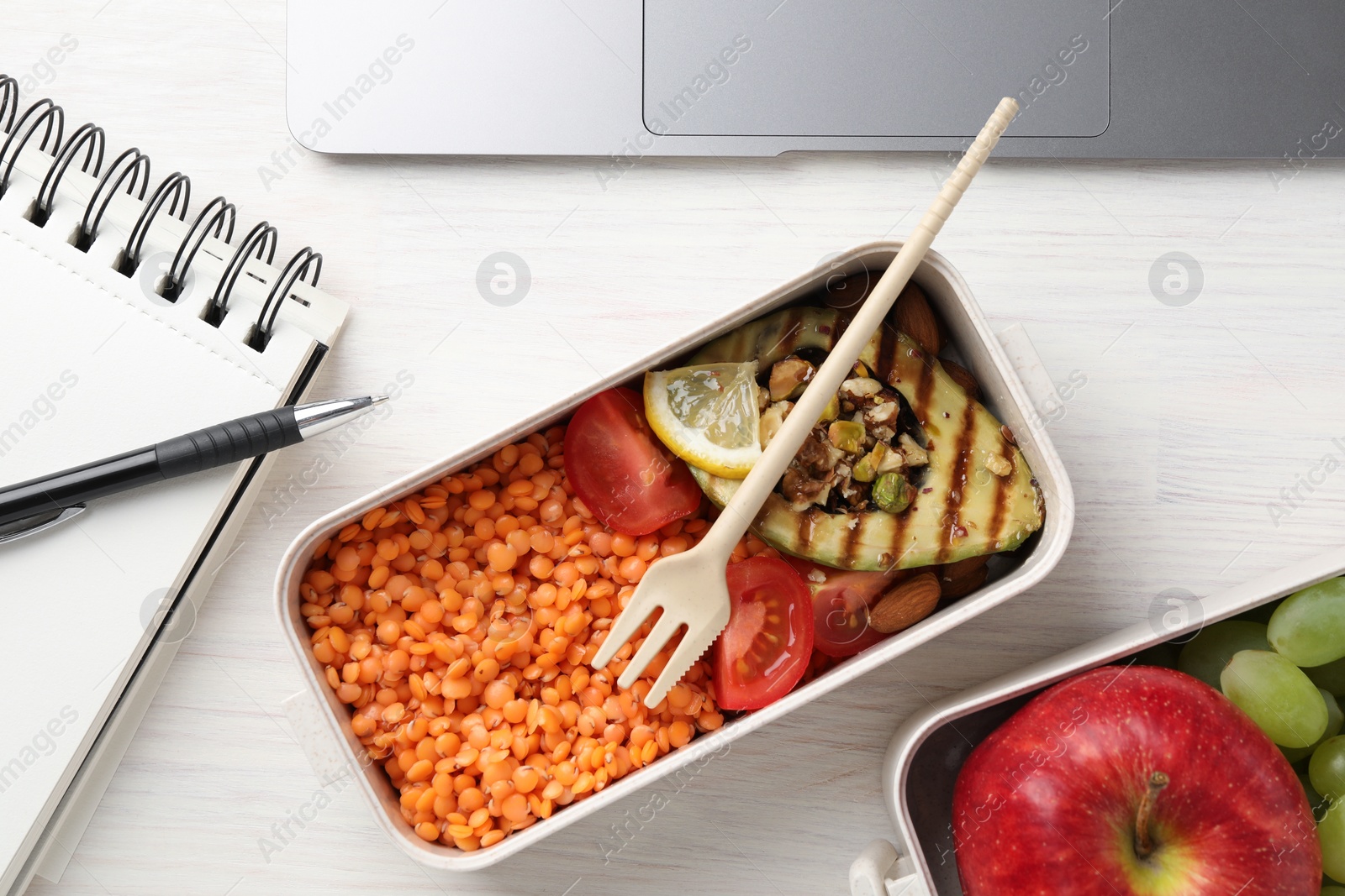 Photo of Healthy products high in vegetable fats near notebook and pen on light wooden table, flat lay