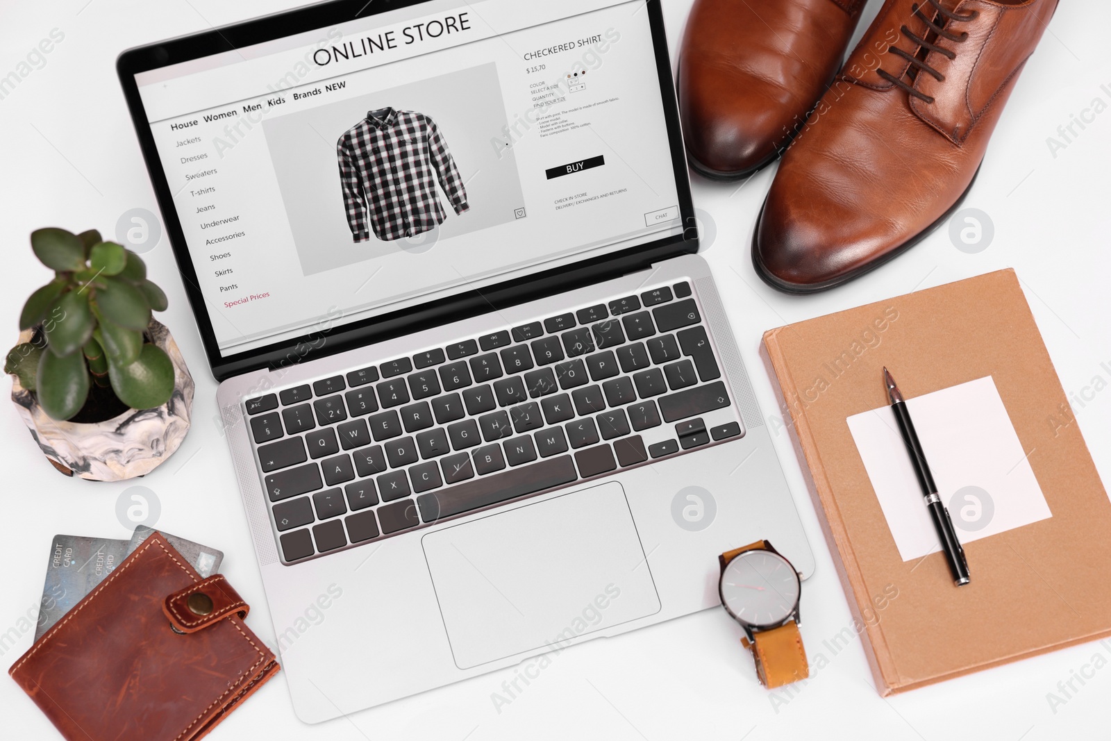 Photo of Online store website on laptop screen. Computer, stationery, credit cards, men's shoes and accessories on white background, above view