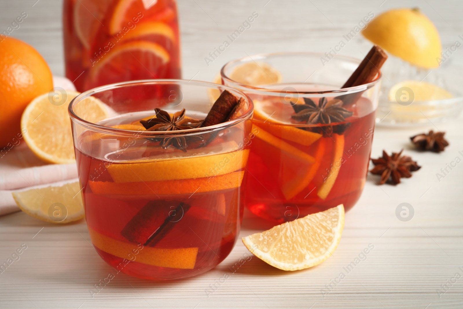 Photo of Aromatic punch drink and ingredients on white wooden table