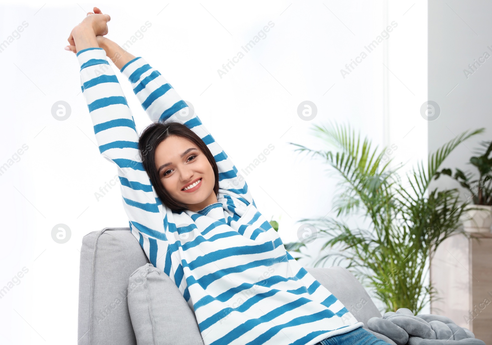 Photo of Young woman relaxing on couch at home