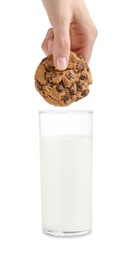 Photo of Woman dipping delicious chocolate chip cookie into glass of milk on white background, closeup