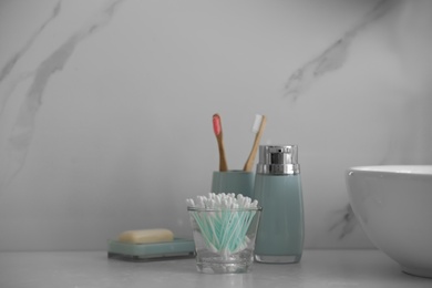 Photo of Cotton buds and toiletries on white countertop