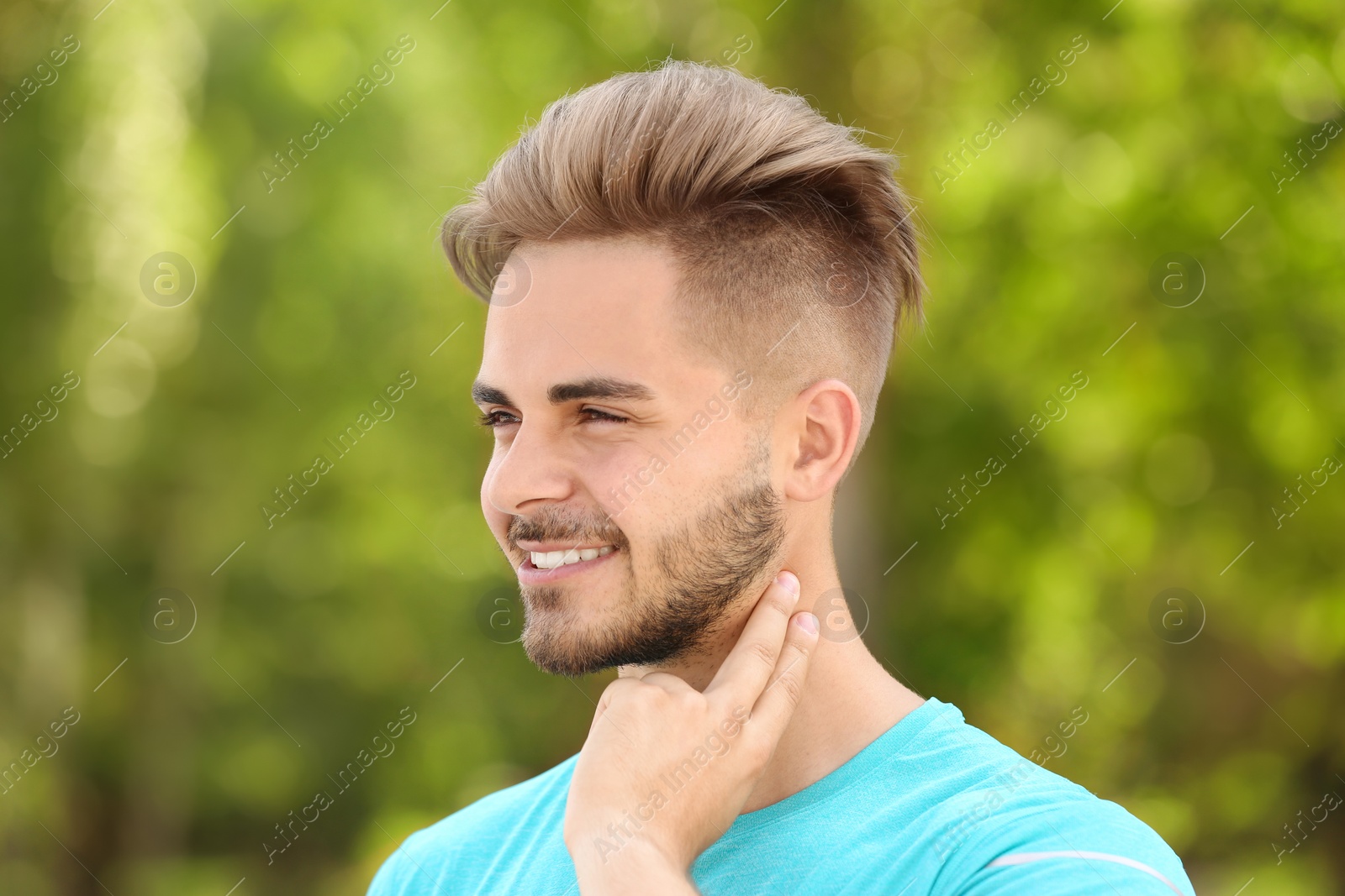 Photo of Young man checking pulse outdoors on sunny day