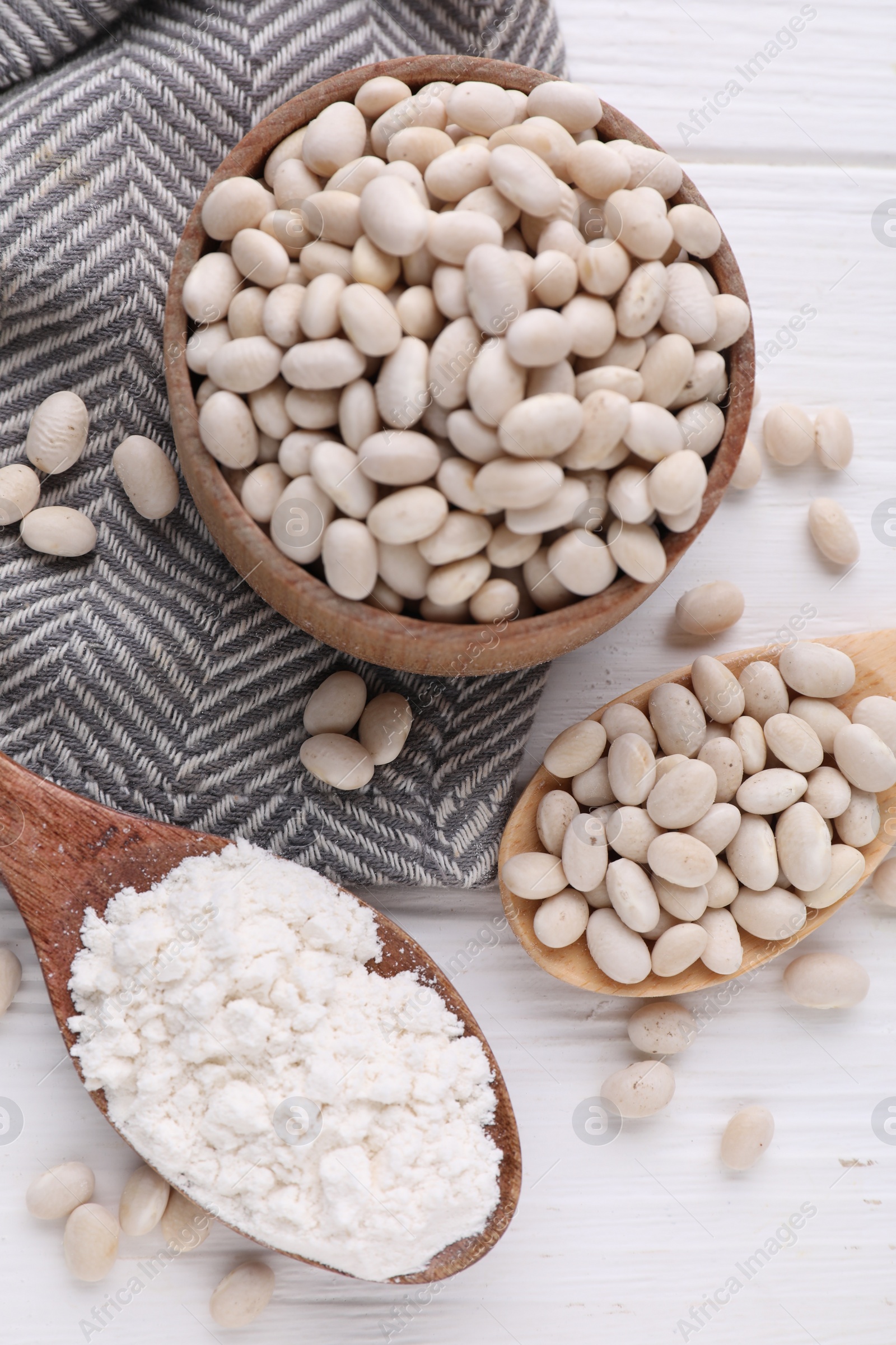 Photo of Kidney bean flour and seeds on white wooden table, flat lay