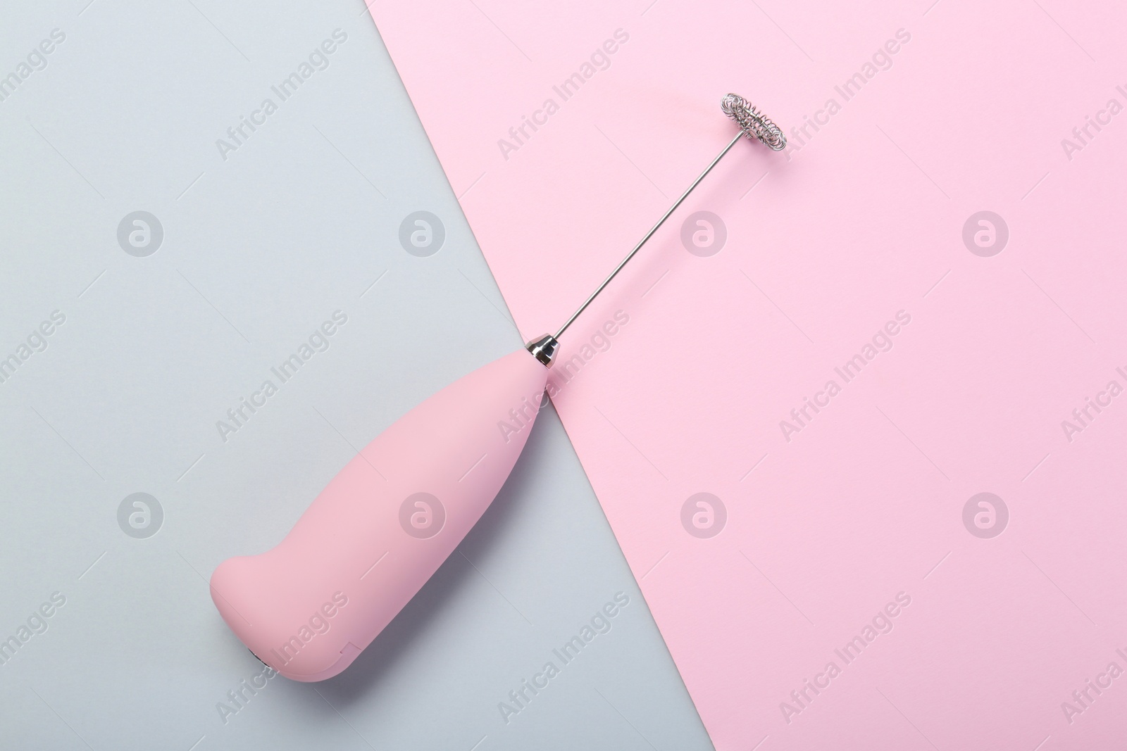 Photo of Pink milk frother wand on color background, top view