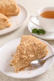 Photo of Piece of delicious Napoleon cake served on table, closeup