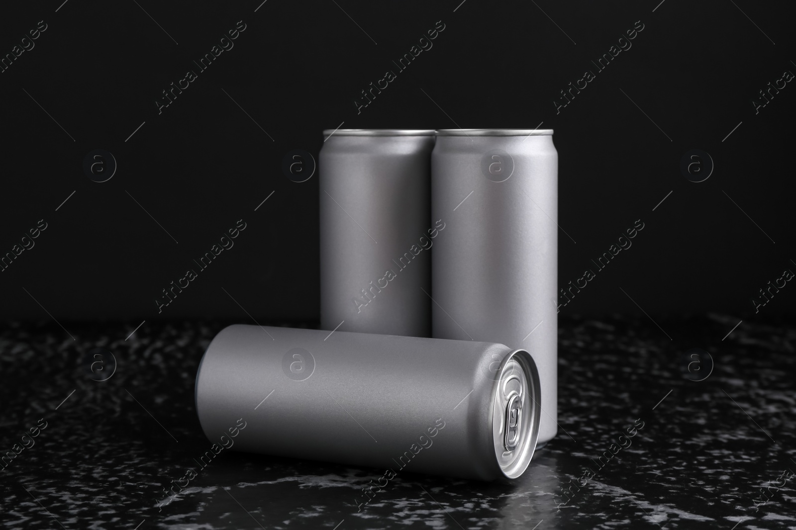 Photo of Energy drinks in cans on black textured table