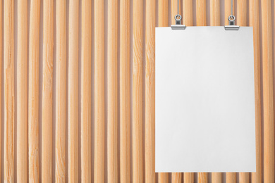 Image of Blank poster hanging near wooden wall. Space for design