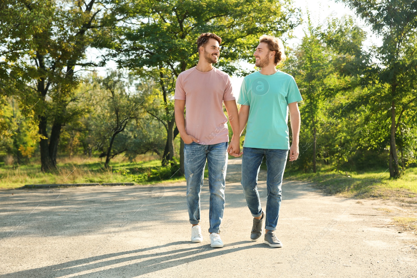 Photo of Happy gay couple walking in green park