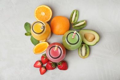 Photo of Flat lay composition with tasty juices and ingredients on grey background