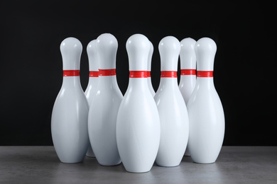 Photo of Set of bowling pins on grey stone table