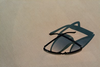 Photo of Stylish sunglasses on grey surface, top view with space for text. Beach accessory