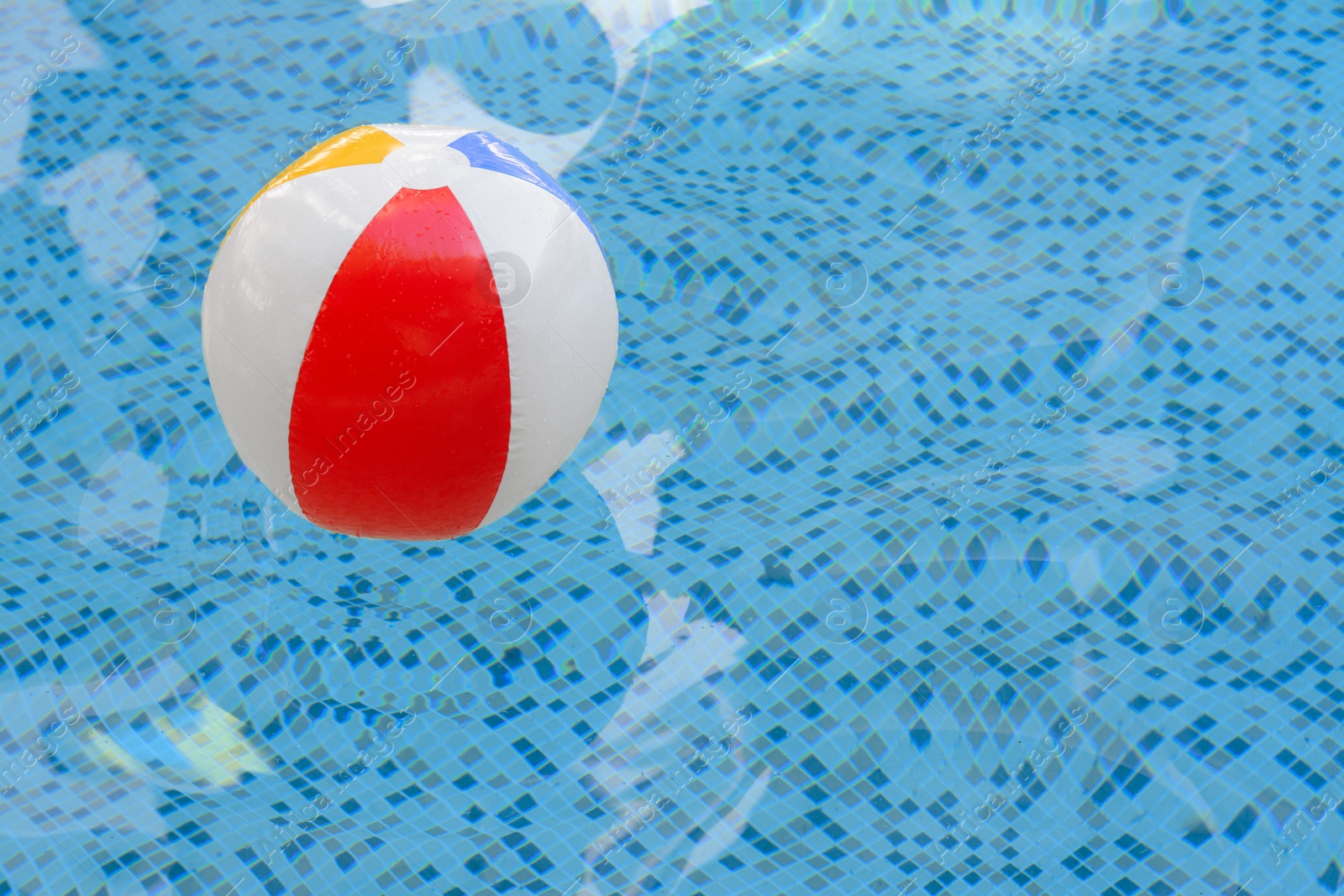 Photo of Inflatable beach ball floating in swimming pool, space for text