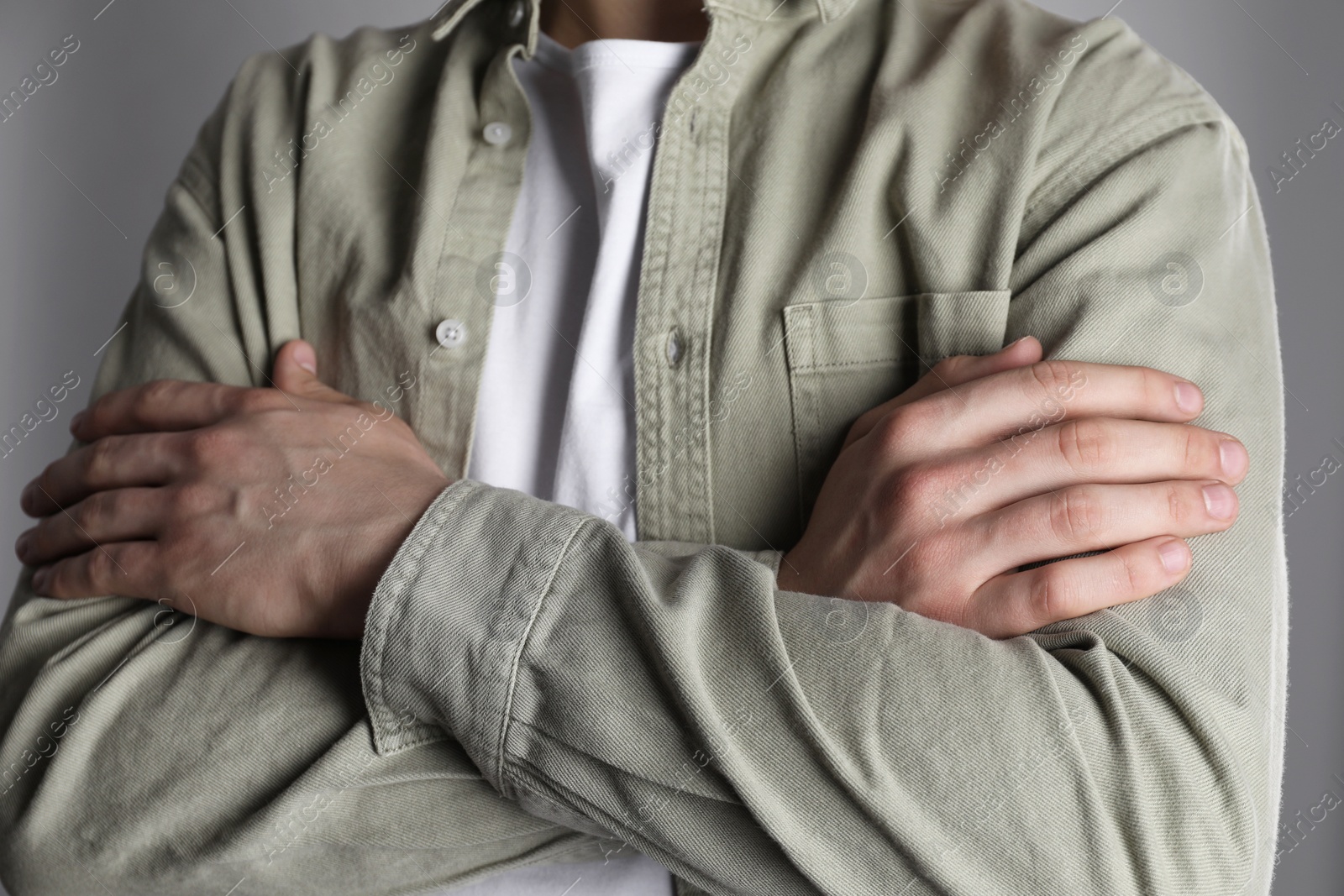 Photo of Man with space for tattoo on his hands against grey background, closeup