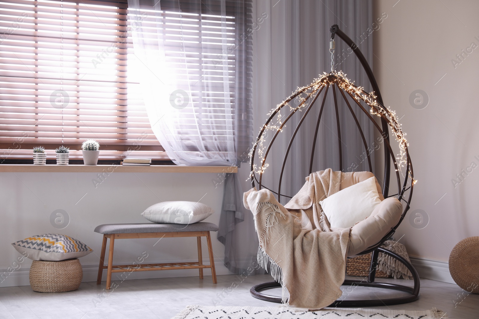 Photo of Cozy hanging chair with fairy lights in modern living room. Interior design