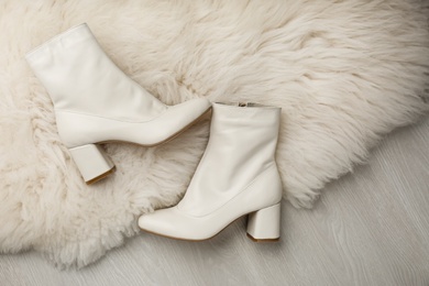 Photo of Pair of stylish leather shoes on faux fur, flat lay