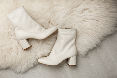 Pair of stylish leather shoes on faux fur, flat lay