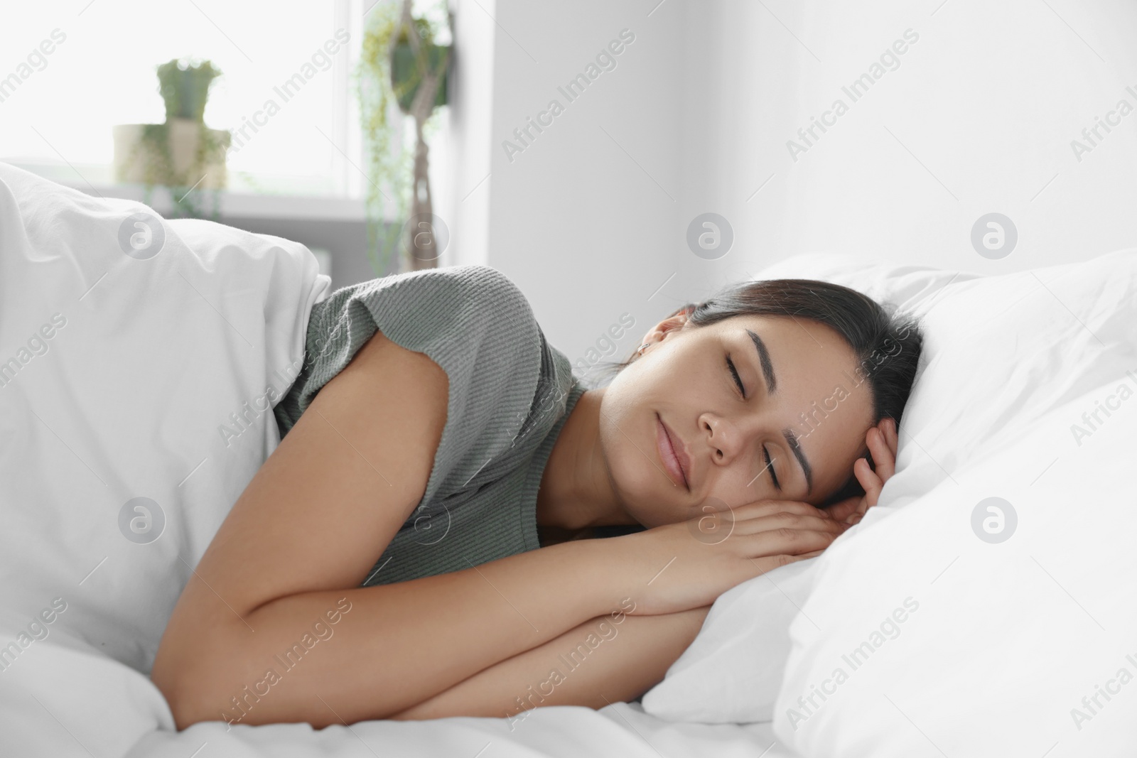 Photo of Beautiful young woman sleeping on soft pillow in bed at home
