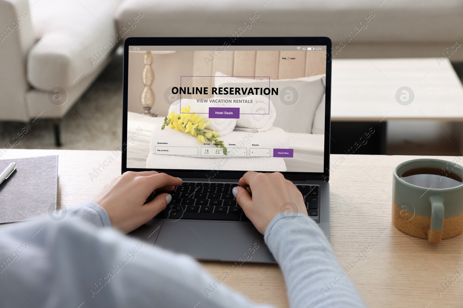 Image of Woman using laptop to book hotel at wooden table, closeup