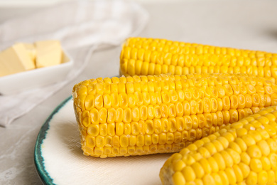 Photo of Delicious boiled corn on plate, closeup view