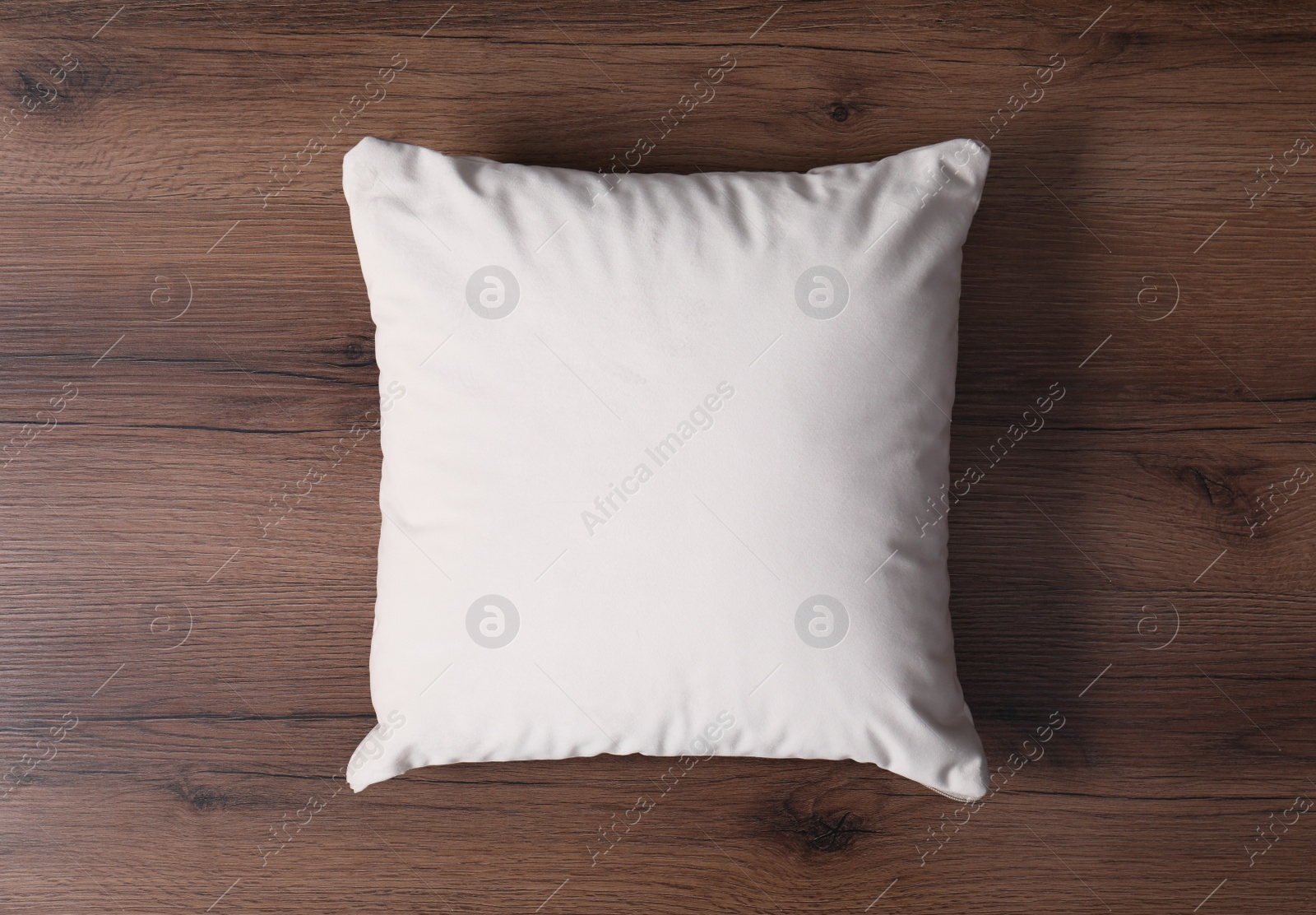 Photo of Blank soft pillow on wooden background, top view