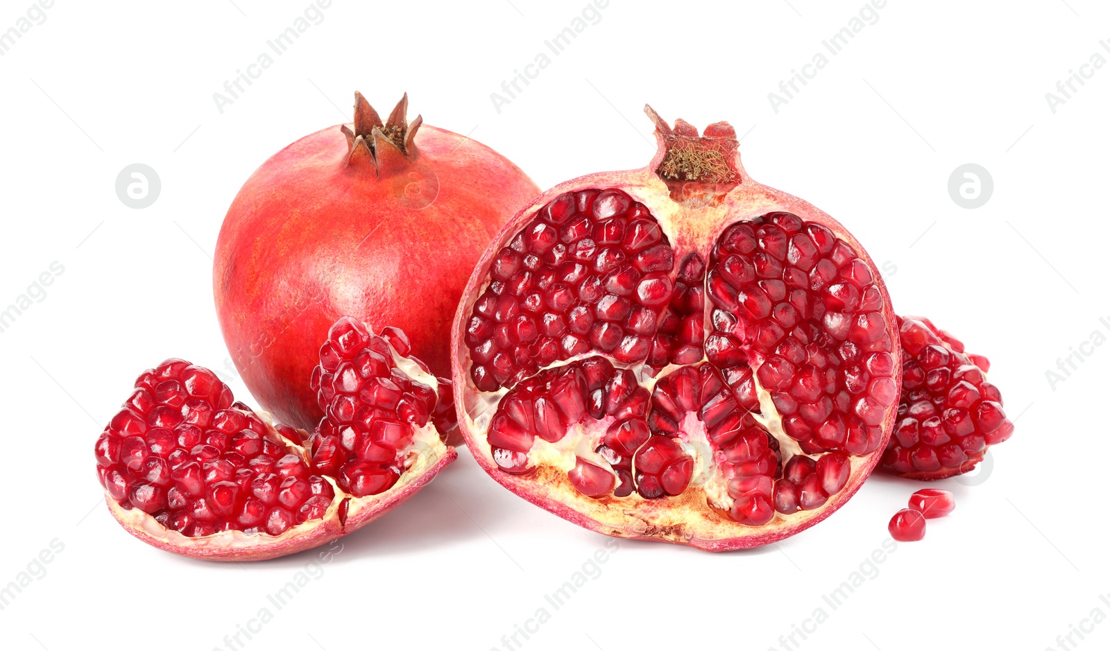 Photo of Cut and whole pomegranates isolated on white