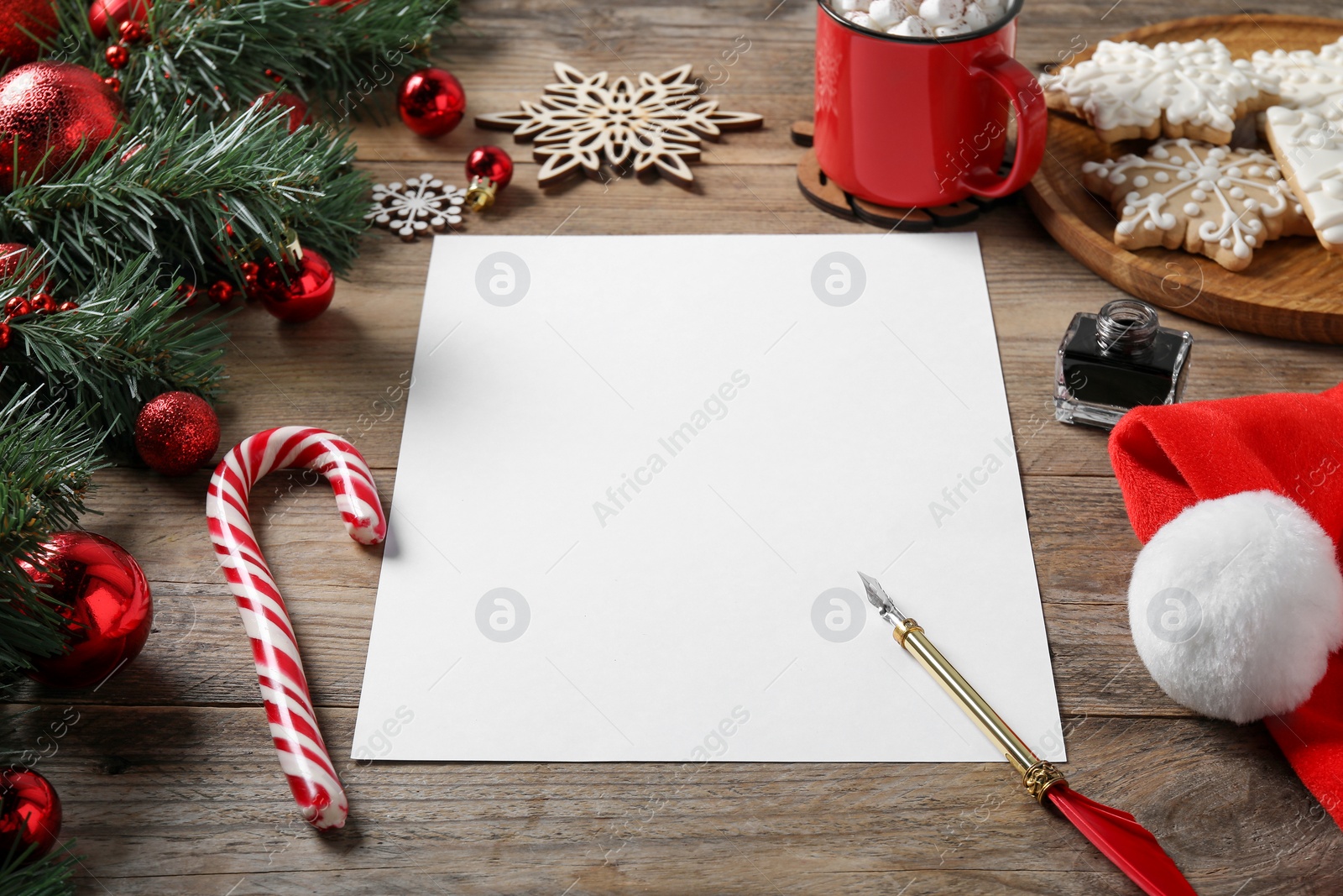 Photo of Blank paper sheet and Christmas decor on wooden table, space for text. Letter for Santa