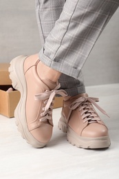 Photo of Woman wearing stylish leather shoes indoors, closeup