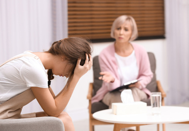 Psychotherapist working with teenage girl in office