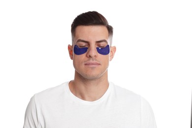 Man with blue under eye patches on white background