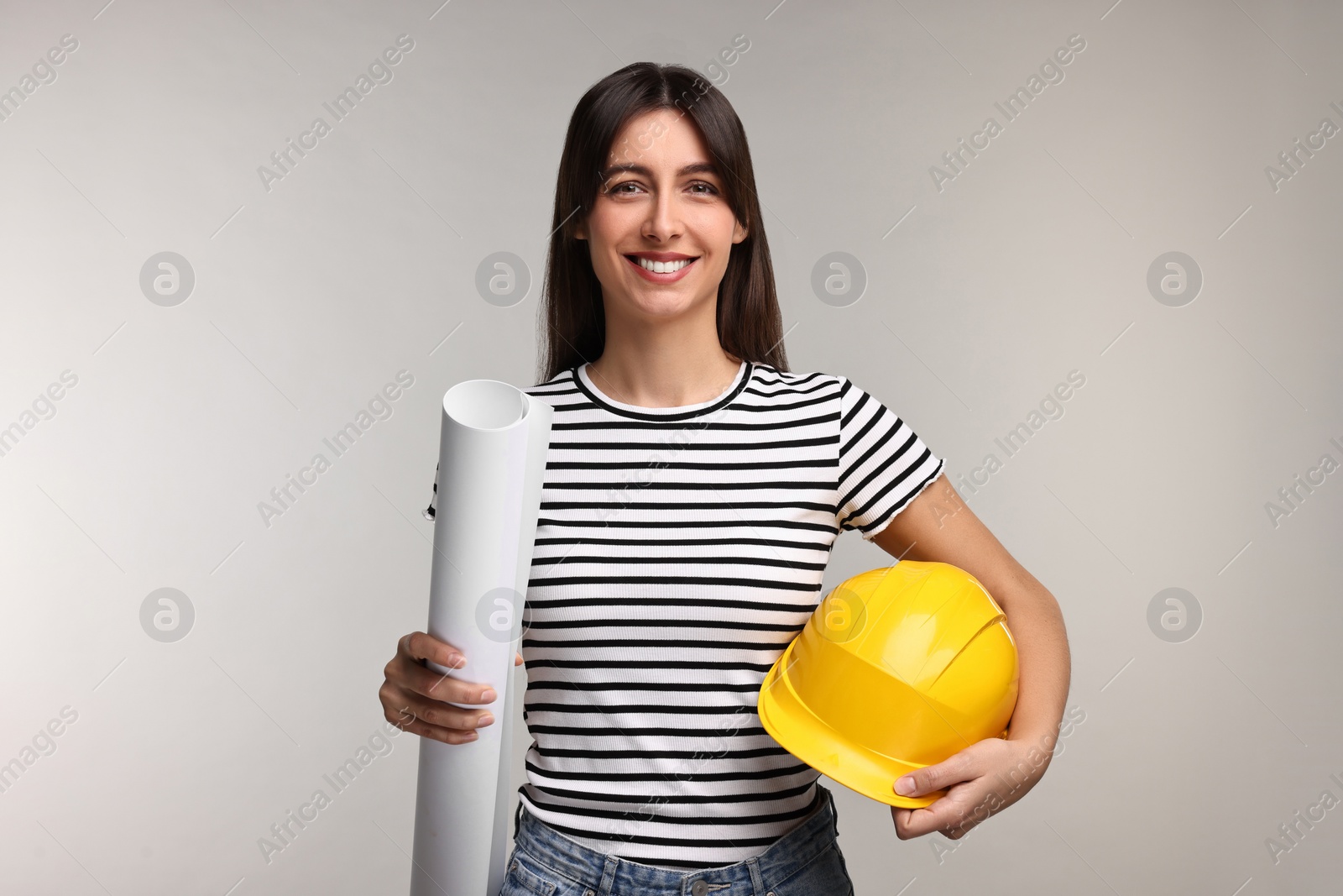 Photo of Architect with hard hat and draft on light grey background