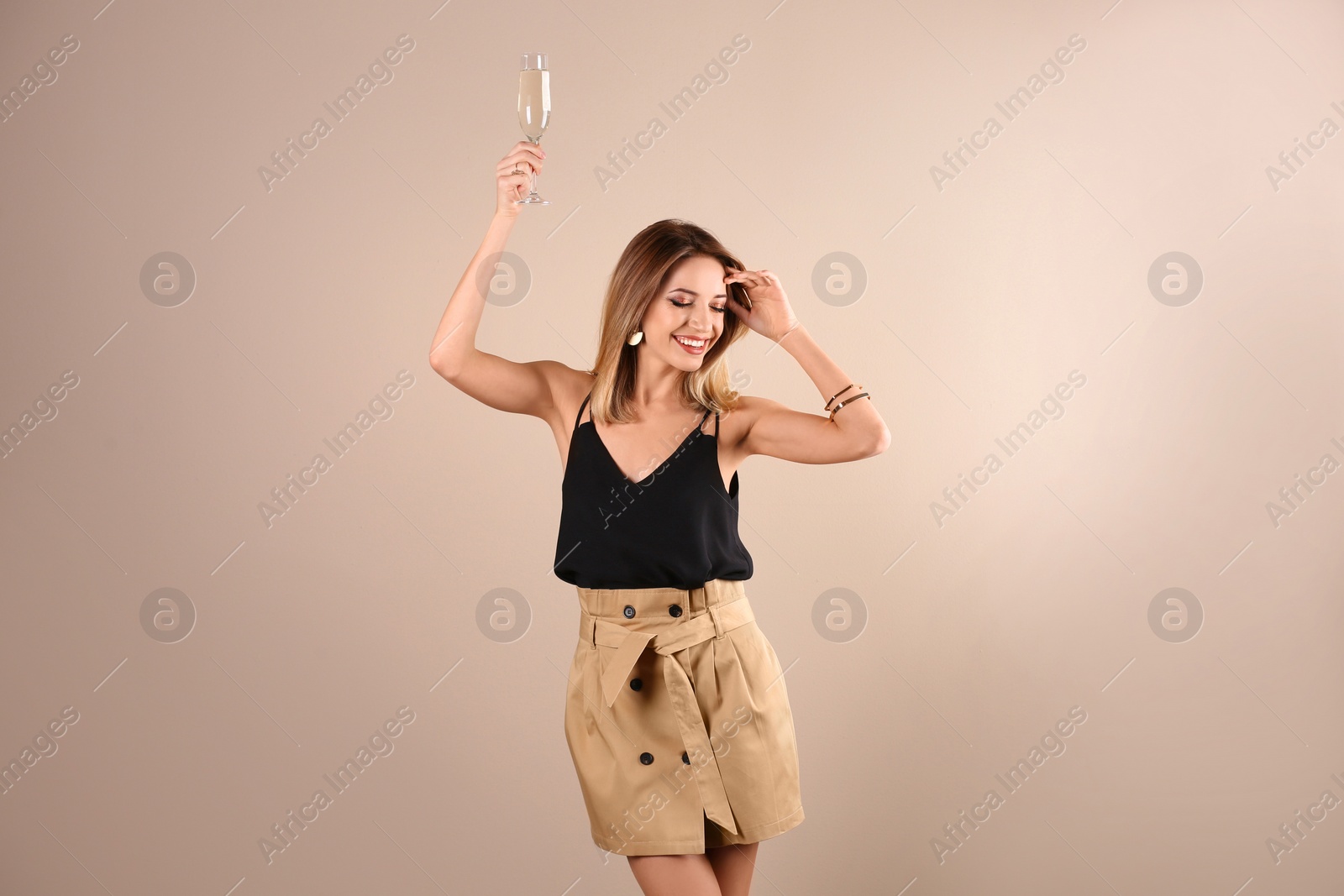 Photo of Portrait of happy woman with champagne in glass on color background