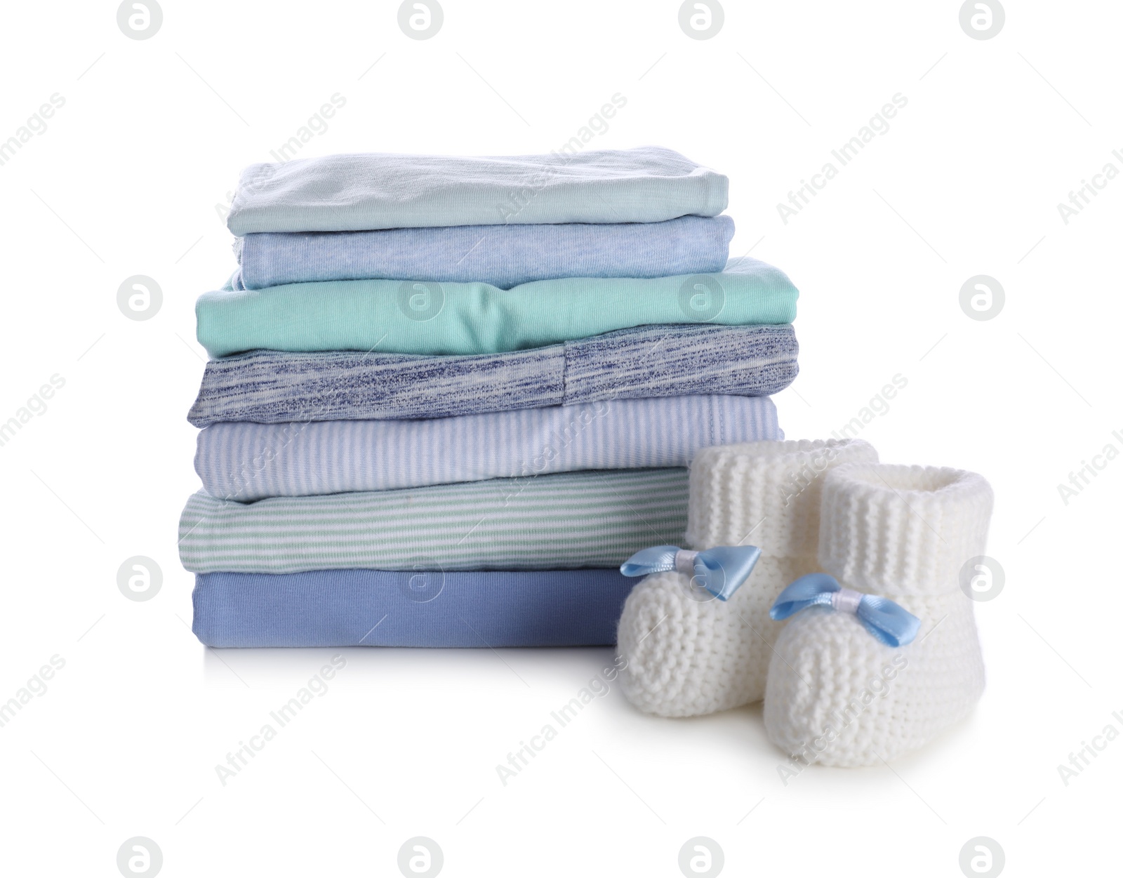 Photo of Stack of clean baby's clothes and small booties on white background