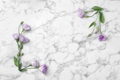 Photo of Flat lay composition with beautiful Eustoma flowers on marble table, space for text