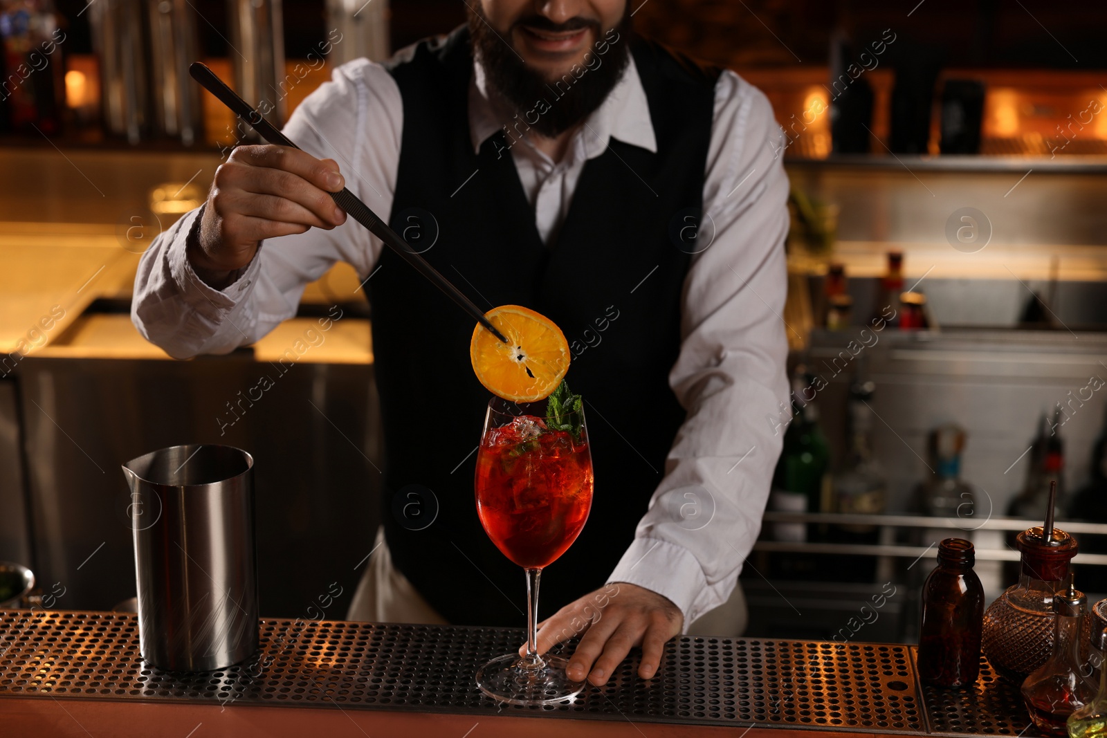 Photo of Bartender making fresh alcoholic cocktail at bar counter, closeup