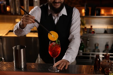 Bartender making fresh alcoholic cocktail at bar counter, closeup