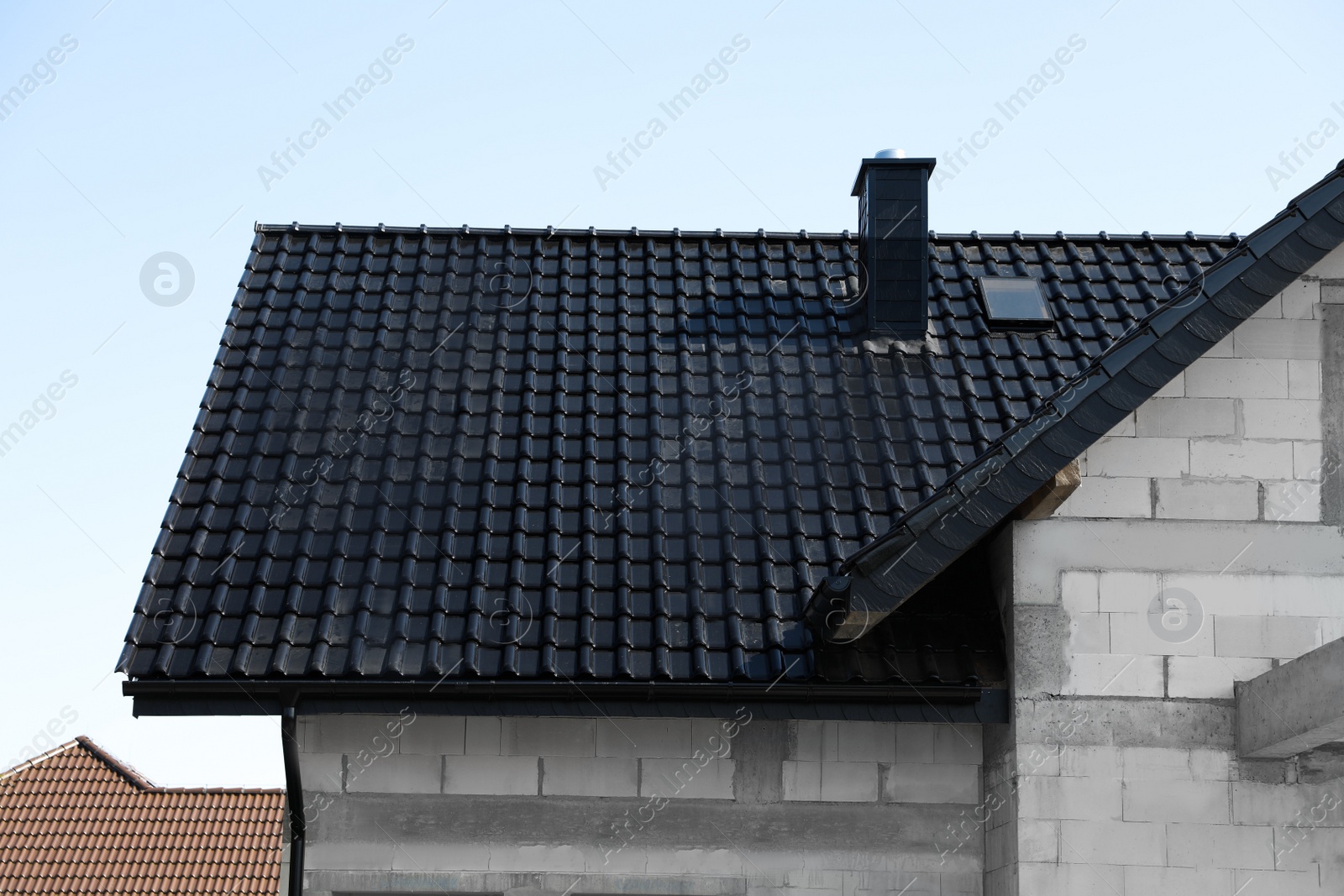 Photo of Unfinished house with black roof against blue sky