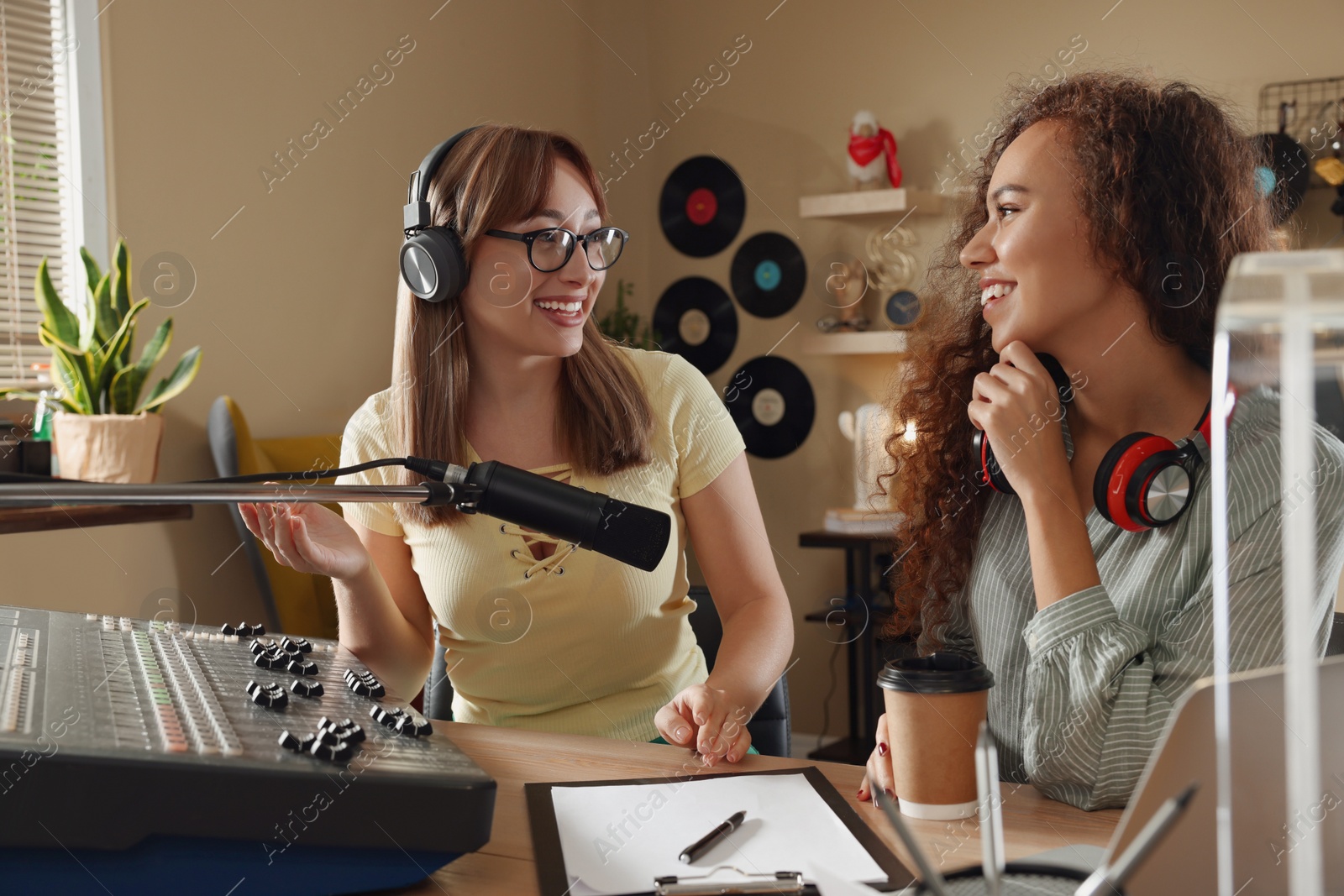 Photo of Radio host interviewing young African American woman in modern studio