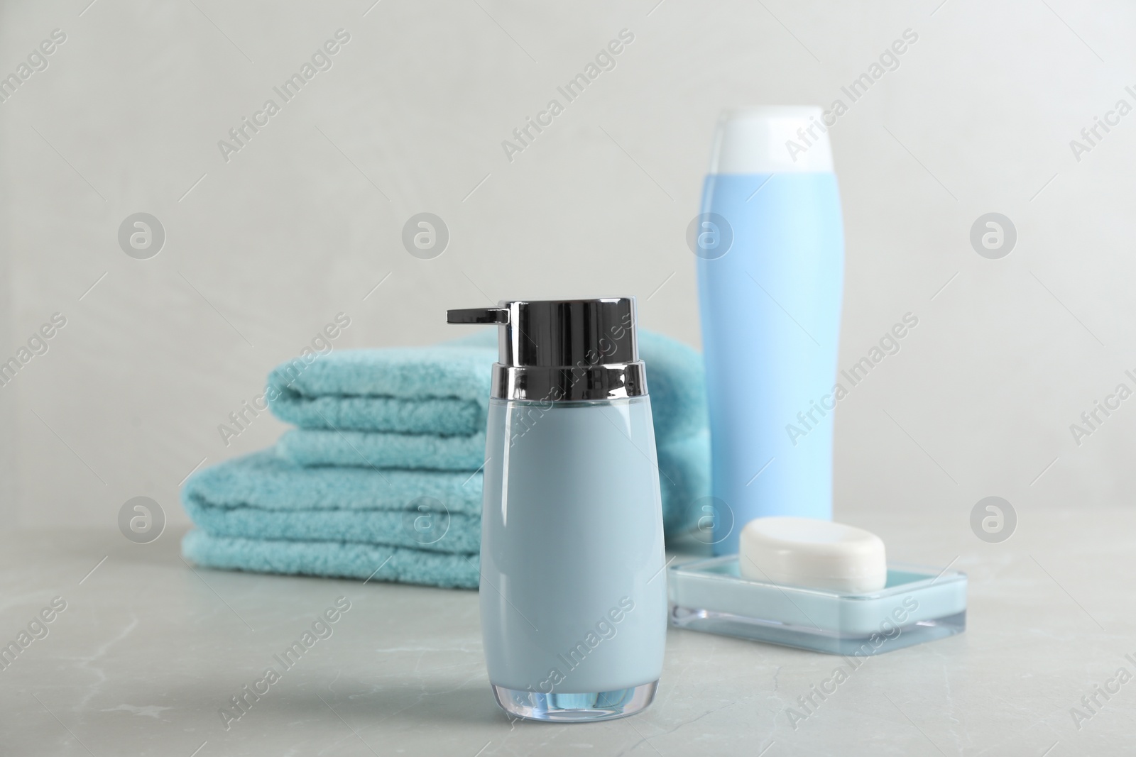 Photo of Fresh towels and toiletries on light grey marble table