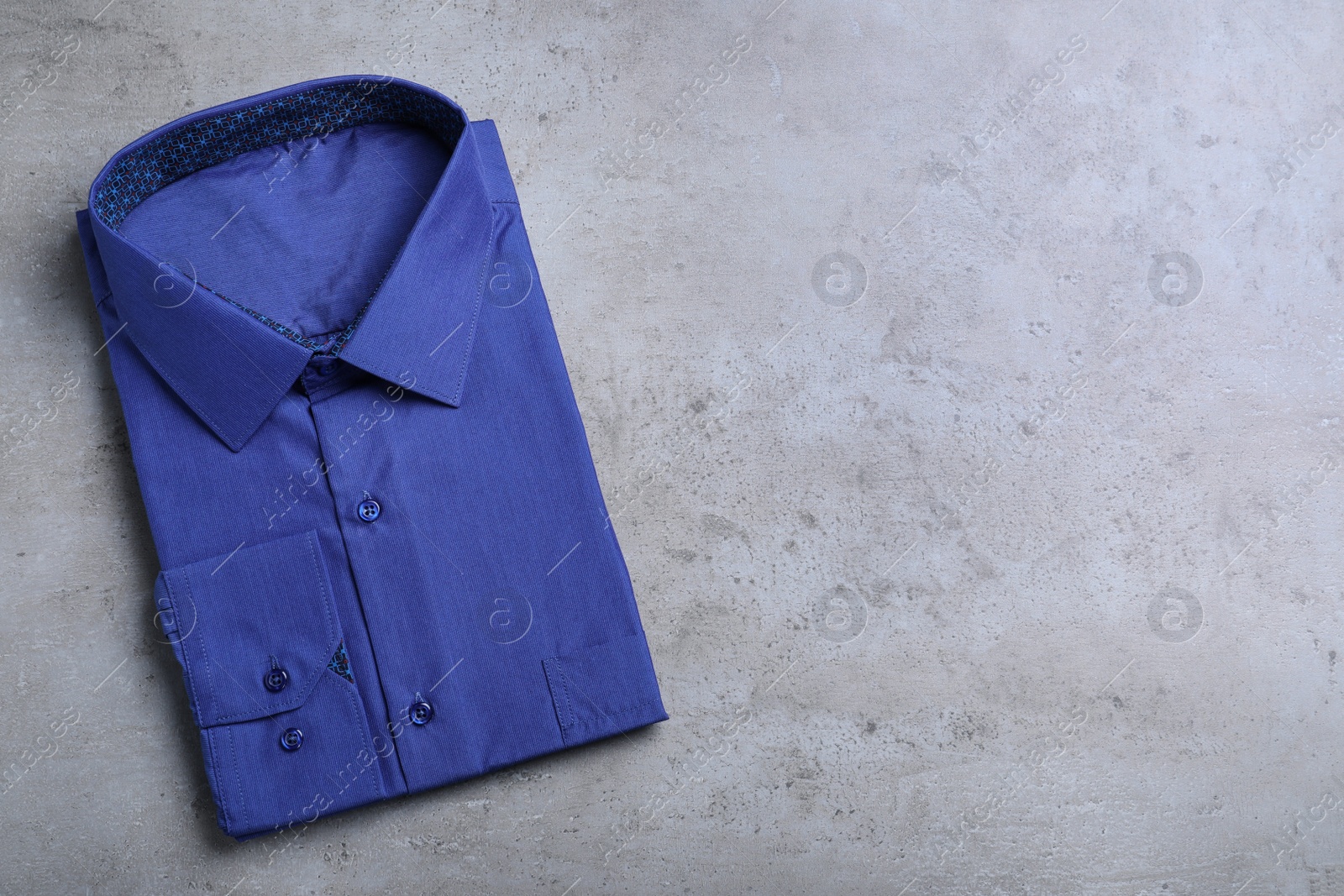 Photo of Stylish blue shirt on grey background, top view with space for text. Dry-cleaning service