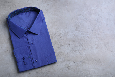 Photo of Stylish blue shirt on grey background, top view with space for text. Dry-cleaning service