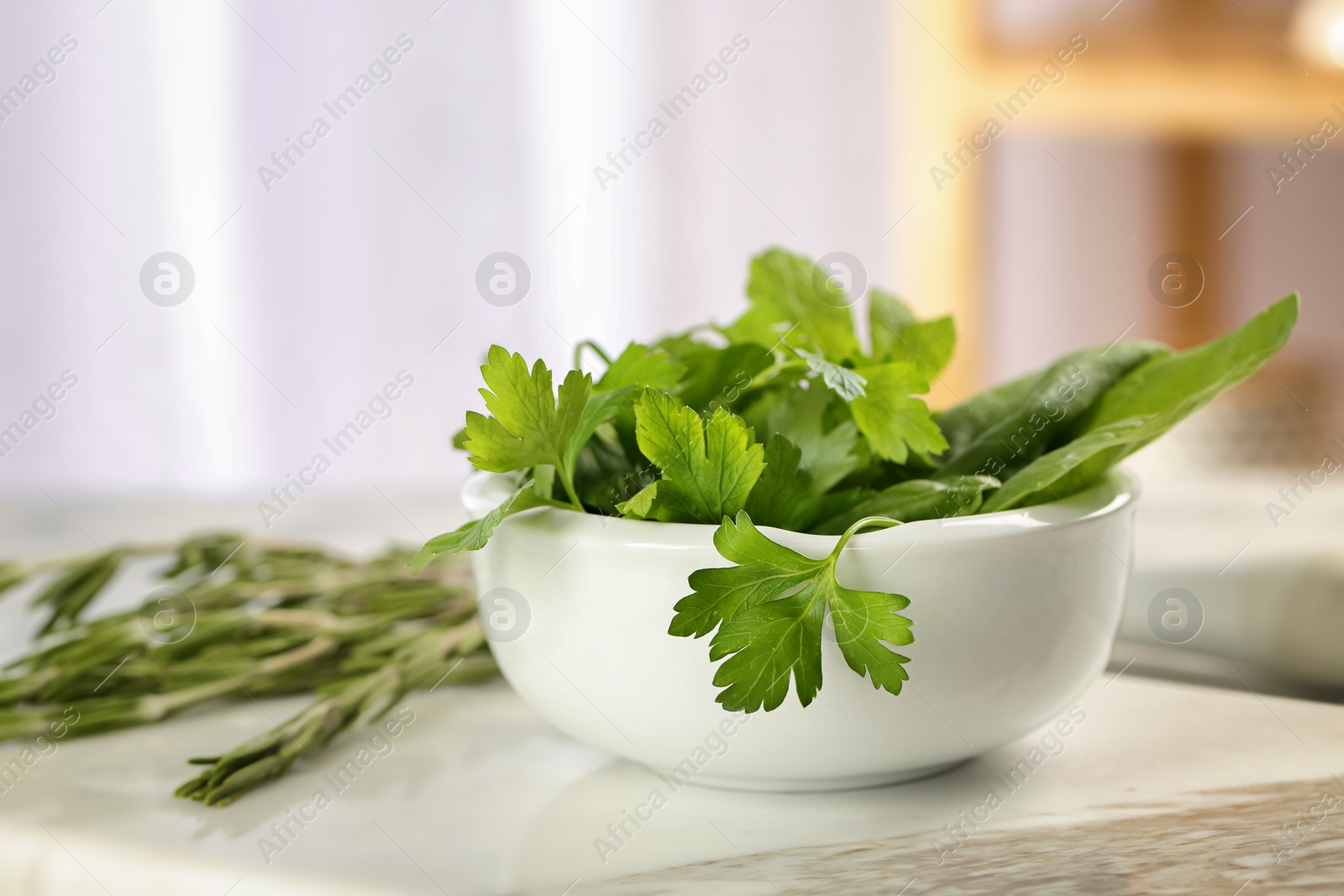 Photo of Bowl with fresh herbs on table