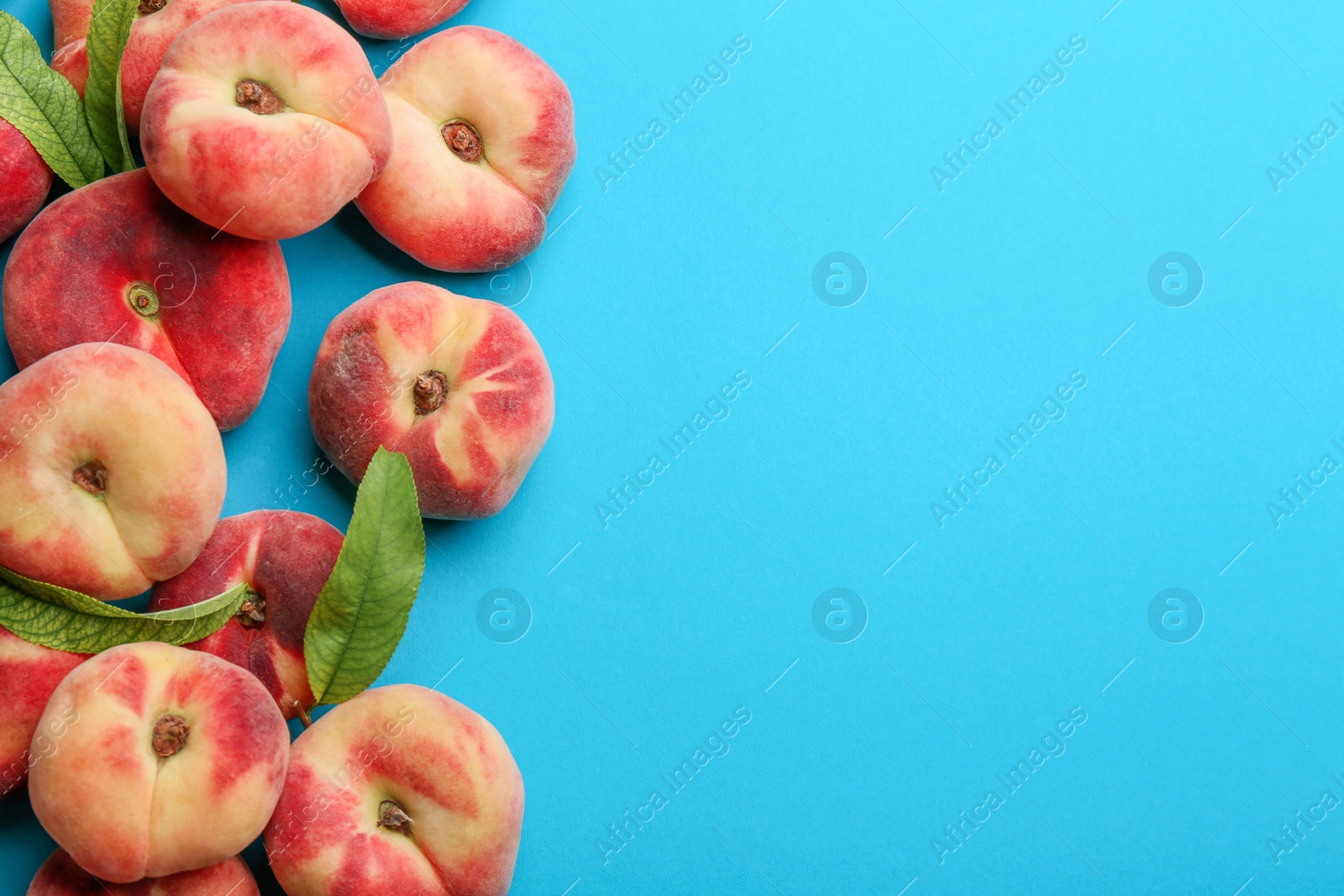 Photo of Fresh donut peaches on blue background, flat lay. Space for text