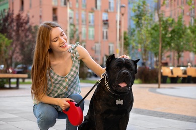 Photo of Young woman with American Staffordshire Terrier dog outdoors