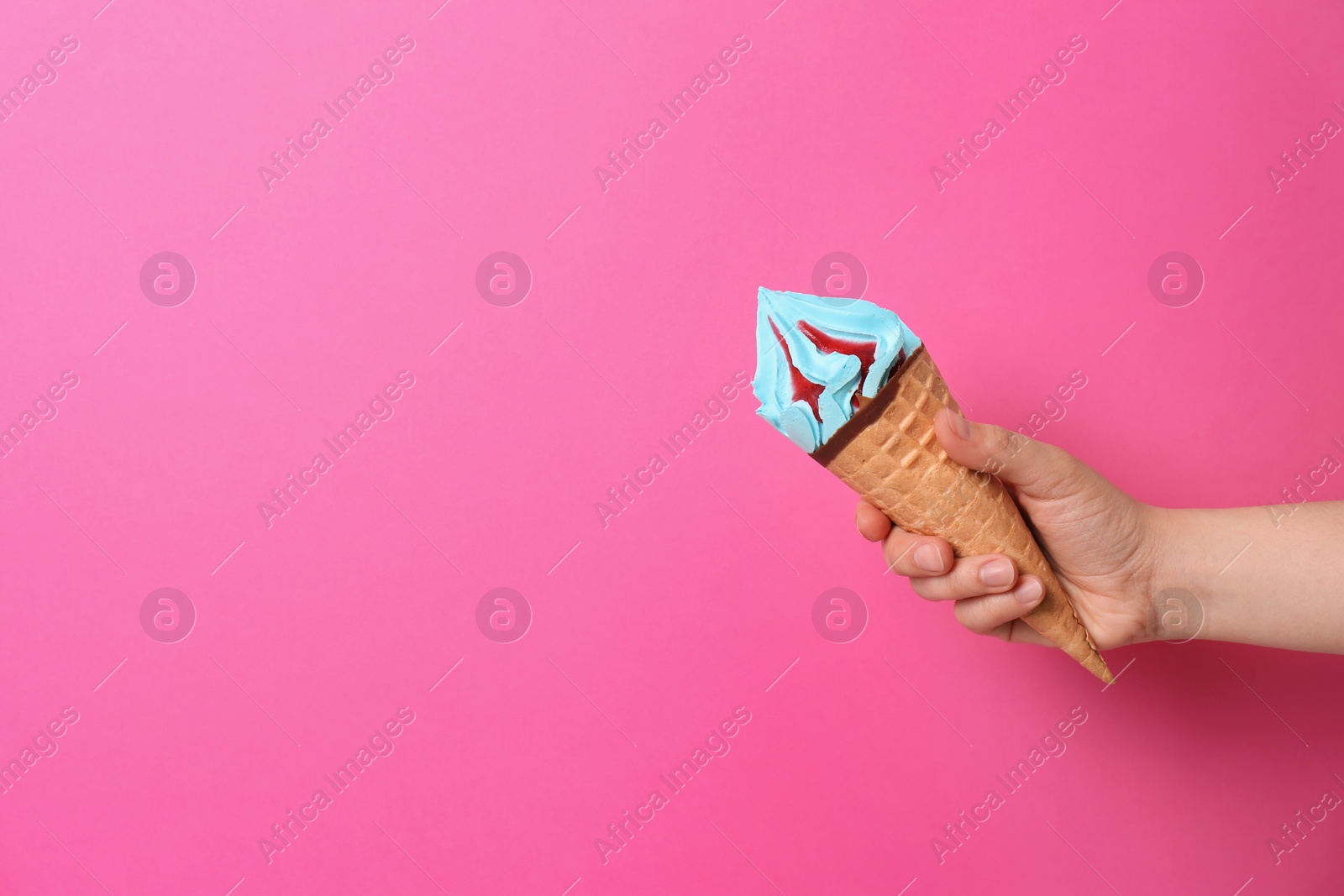 Photo of Woman holding waffle cone with delicious ice cream on color background. Space for text