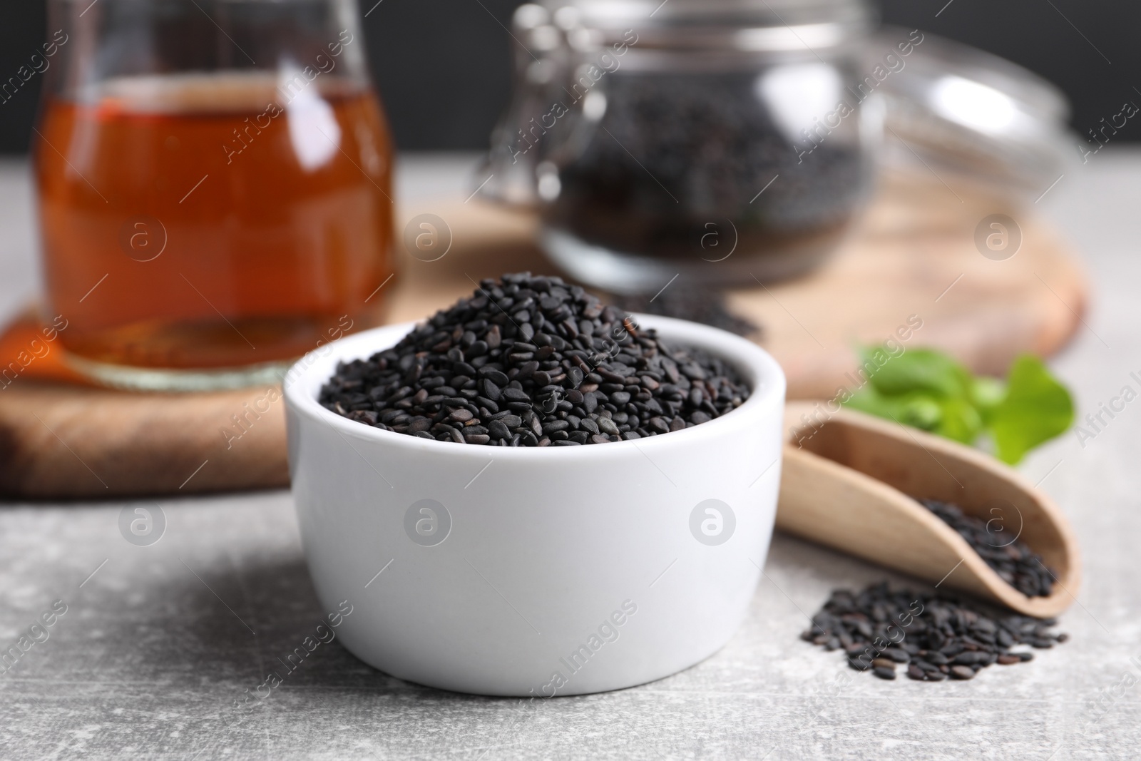 Photo of Black sesame seeds on grey table, closeup