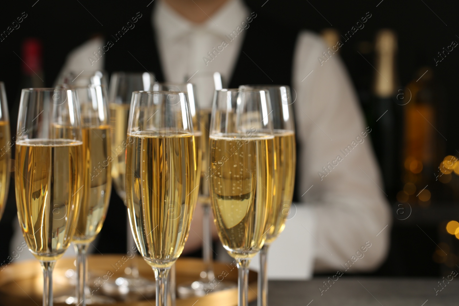 Photo of Glasses of champagne and waiter in restaurant, closeup. Space for text
