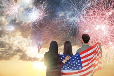 Image of 4th of July - Independence day of America. Family with national flags of United States enjoying fireworks in sky